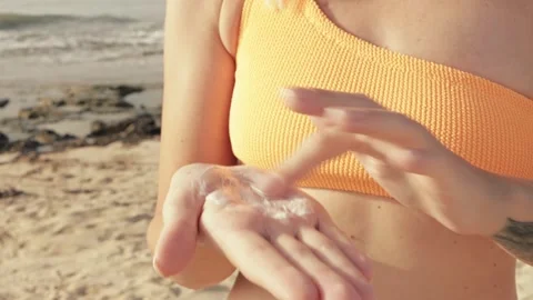 Sunscreen application on sandy beach, woman carefully rubbing protective lo.. Video stock 313298119