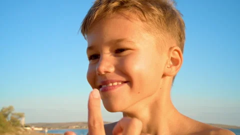 Sunscreen is applied to the boy's face Stock Footage 330119331