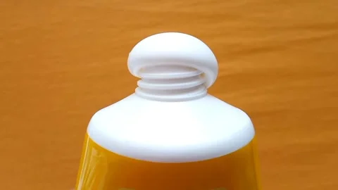 Sunscreen Cream Texture Squeezed From Tube on Yellow Background, Stock Footage 327900062