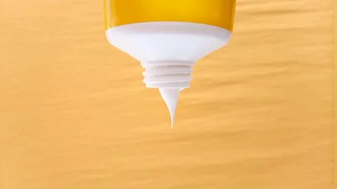 Sunscreen Cream Texture Squeezed From Tube on Yellow Background, Stock Footage 327900063