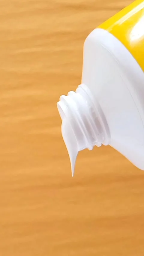 Sunscreen Cream Texture Squeezed From Tube on Yellow Background Stock Footage 327900093