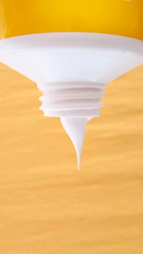 Sunscreen Cream Texture Squeezed From Tube on Yellow Background Video stock 327900099