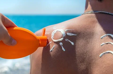 Sunscreen on the man back. Selective focus. Stock Photos