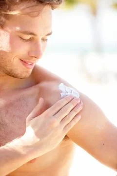 Sunscreen Man putting sun screen / sun block on shoulder Stock Photos