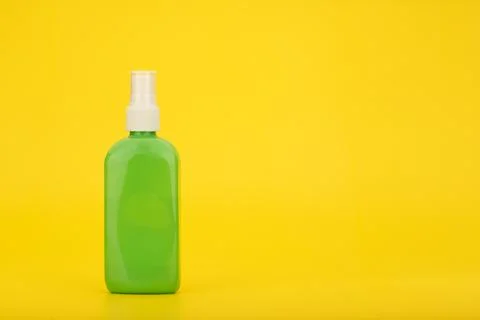 Sunscreen spray against yellow background with copy space. Sunscreen product for Stock Photos