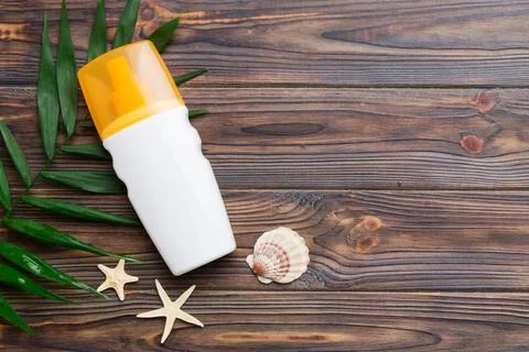 Sunscreen spray bottle. Bottle with sun protection cream and sea shells with  Stock Photos