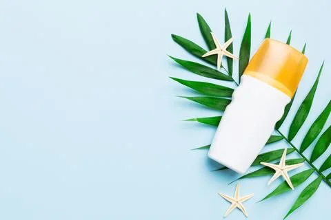Sunscreen spray bottle. Bottle with sun protection cream and sea shells with  Stock Photos