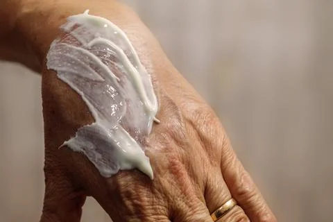 Sunscreen spread on an elderly lady's hand Fotos Stock