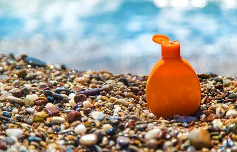 Sunscreen stands on the beach. Selective focus. Stock Photos