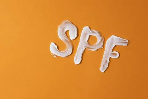 Sunscreen texture on a colored background, top view. Foto stock