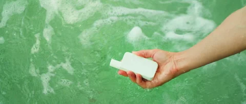 Sunscreen in water's grasp. Hand submerged, presenting a sunscreen bottle in sea Stock Footage 264655268