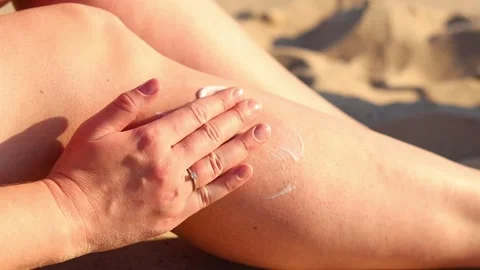 Sunscreen on a woman's leg. Close-up of a heart drawn with sunscreen on the skin Stock Footage 312468028