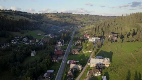 Sunset 4k drone view of a mountain village nestled between hills Stock Footage 226400083