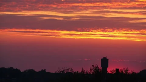 Sunset in 8K resolution, with a water tower visible in the background. Stock Footage 334679027