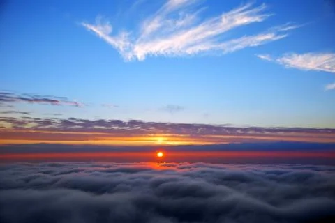 Sunset above clouds Stock Photos