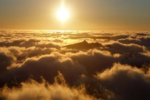 Sunset above the clouds. The row of windmills on top of a mountain. Stock Photos