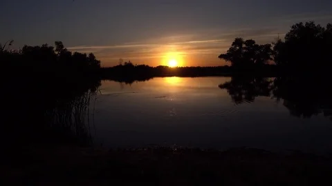 Sunset above river next to darkness Stock Footage 79596279