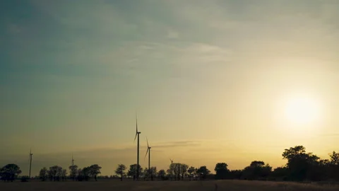 Sunset above the windmills on the field . Wind power technology - turbine Vidéo 133609336