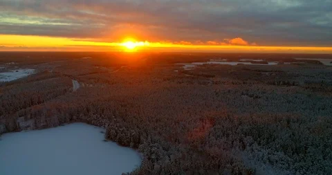 Sunset above winter forest, C4k aerial, reverse, drone shot, of forest covere Stock Footage 99325590