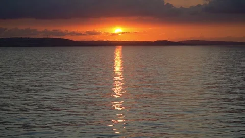 A sunset across the ocean as seen from a ship at sea Stock Footage 122827322