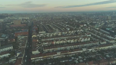 Sunset aerial descending over rows of colourful suburban English houses in South Stock Footage 144751329