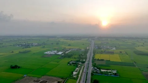 Sunset Aerial Orbit of Highway Through Lush Punjab Farmland 動画素材 333070035