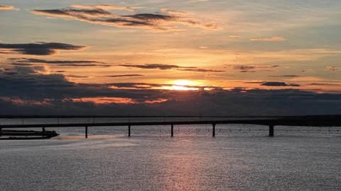 Sunset aerial over lagoon with bridge and aquaculture 4K Stock Footage 339863768