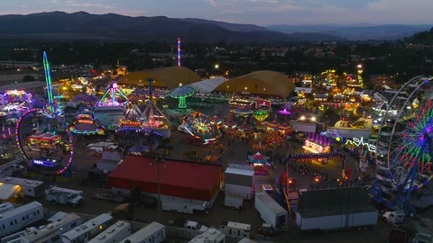 Sunset aerial over a large county fair and fair grounds, with ferris wheel, Stock Footage 94264865