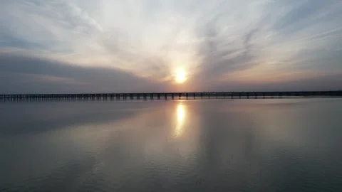 Sunset aerial reflection over long bridge and calm water in China Stock Footage 337886420