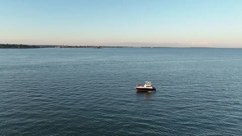 Sunset aerial video of persons jumping off a large boat 스톡 동영상 249852919