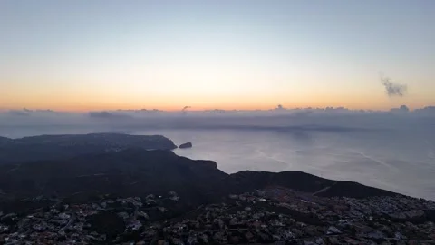 Sunset aerial view of Cumbre del Sol coastal cliffs and Mediterranean waters Видео 337028450