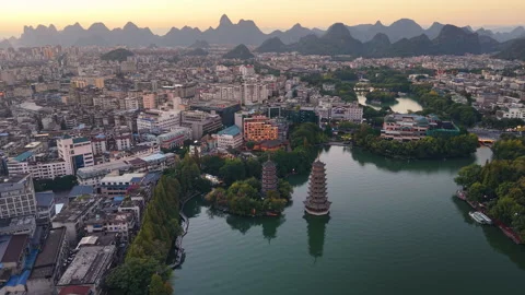 Sunset aerial view of Sun and Moon Twin Pagodas at Shanhu Lake, Guilin, China Stock Footage 330444888