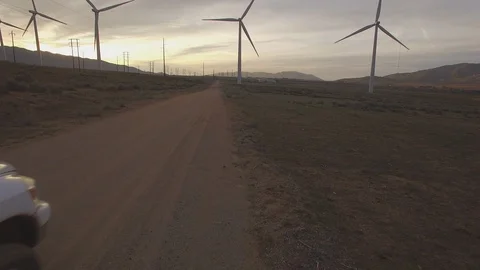 Sunset Aerials of Spinning Wind Turbines and Pick-Up Truck 库存影片 103290402
