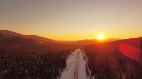 Sunset against the backdrop of the mountains of the winter track Stock Photos