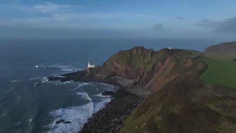 Sunset against cliffs with lighthouse - aerial/drone shot - Hartland, Devon Stock Footage 270208859