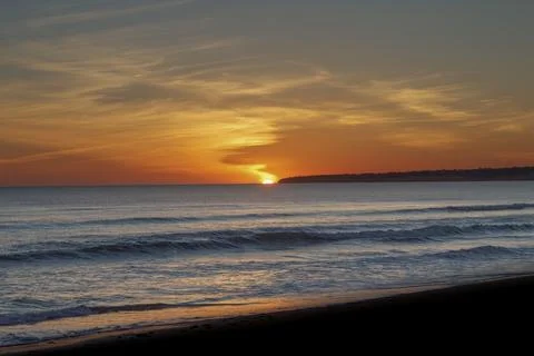 Sunset at Albufeira  over the ocean with waves crashing on the shore at a beach Stock Photos