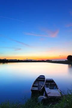 Sunset along the pond with two boats Foto stock