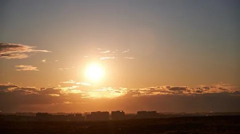 Sunset among the evening clouds. Red sun in the evening sky, timelapse Stock Photos