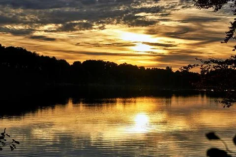 Sunset and clouds are reflected in the lake. Germany Stock Photos