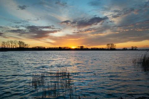 Sunset and clouds over a calm lake Stock Photos