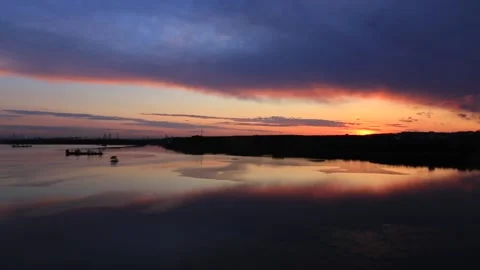 The sunset and clouds by the riverbank delay the urban scenery Stock Footage 274122583