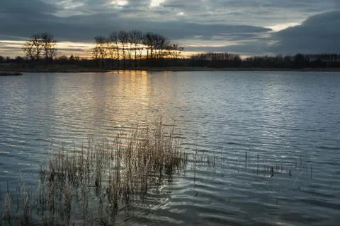 Sunset and dark clouds over the lake Stock Photos