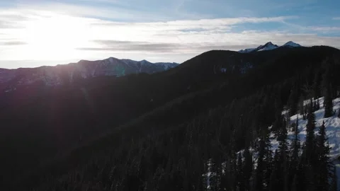 Sunset and pine tree covered mountainsides in winter 스톡 동영상 310526668