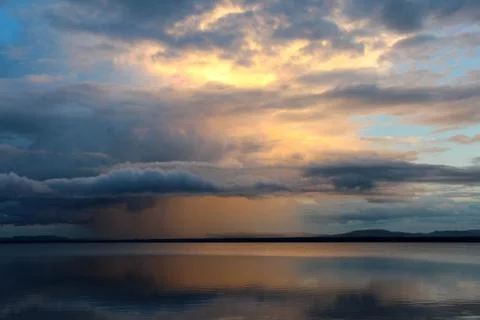 Sunset and rain clouds over Orsa lake in August, Sweden. Stock Photos