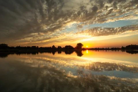 Sunset and reflection of clouds in water Stock Photos