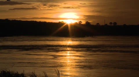Sunset and reflection in Zambezi River with low clouds and silhouetted trees Stock Footage 22883068