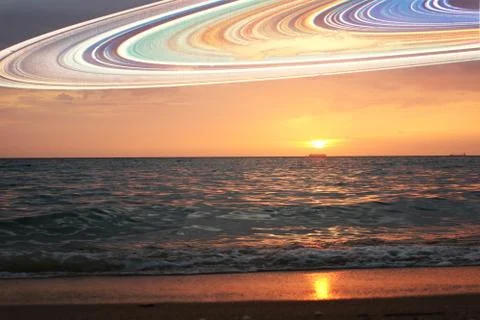 Sunset and saturn ring on horizontal sea water surface colorful cloud sky Stock Photos