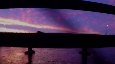 Sunset and traffic on a bridge in hand held slow motion. Vídeo Stock 63357944