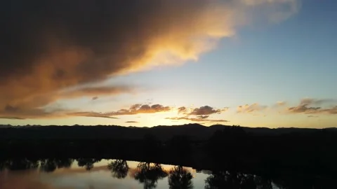 Sunset and trees shown in lake- Drone camera moves back and right Stock Footage 137860697