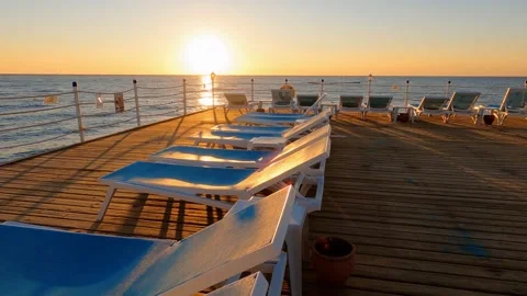 Sunset and a view of the sea and a sunbeds on a pier in Turkey Stock Footage 265656041